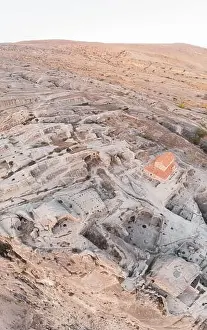 Panoramic view to Uplistsiche cave town caves with basilica in the middle and scenic rocky landscape