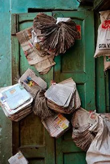 Building Structure Prints: Paper bags made from old newspapers hanging on the door of a store