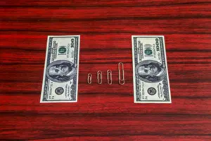 Arranged Prints: Paper clips arranged by size between 100 and 1000 dollar bill