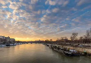Palais Prints: Paris, France - February 12, 2021: Seine river and Grand Palais in background with a beautiful cloudy sunset in Paris