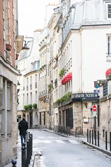 Left Bank Prints: Paris, France - March 2, 2016: Man walking down rue des Grands Augustins in Monnaie on the Left Bank