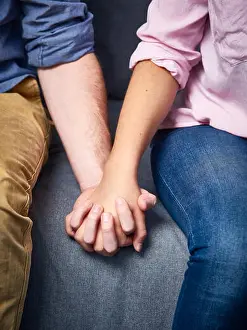 Heterosexual Prints: Partial view of couple holding hands on couch