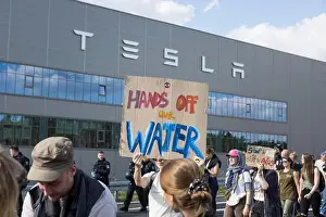 Activism Prints: Participant with sign Hands off our water in front of the Tesla Gigafactory at the demonstration Water