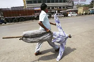 Physical Fitness Prints: A party worker carrying an effigy which is to be burnt while they are protesting in Bombay now Mumbai