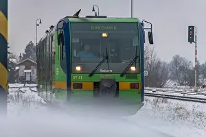 Turntable Prints: Passenger train with motor engine in winter snowy morning in cold village Lenesice CZ 12 09 2023