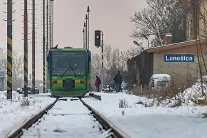 Turntable Prints: Passenger train with motor engine in winter snowy morning in cold village Lenesice CZ 12 09 2023