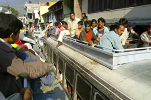 Patience Prints: Passengers travelling on roof of overfull bus meeting another bus