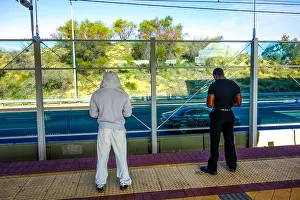 Texting Prints: Two passengers waiting for the train at the station. Dressed in black and white