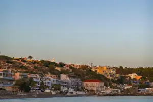 Calm Sea Prints: A peaceful coastal neighborhood at dusk with buildings nestled along the hillside and overlooking the sea