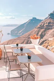 Peaceful view in Santorini, Greece with white architecture and flowers, cruise ships, Mediterranean summer mood, vacation and travel background