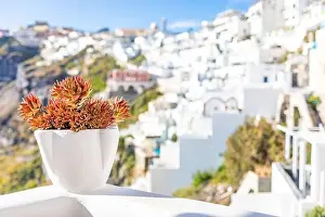 Peaceful view in Santorini, Greece with white architecture and flowers, cruise ships, Mediterranean summer mood, vacation and travel background