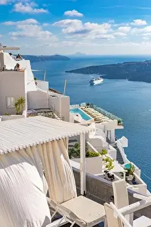 Peaceful view in Santorini, Greece with white architecture and flowers, cruise ships, Mediterranean summer mood, vacation and travel background