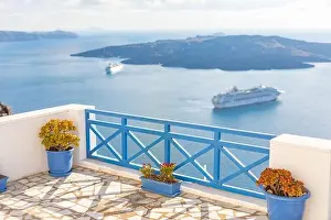 Peaceful view in Santorini, Greece with white architecture and flowers, cruise ships, Mediterranean summer mood, vacation and travel background