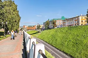 White People Prints: Pedestrian street with a white stone fence, with people walking