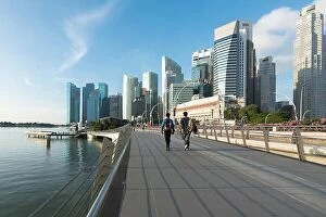 Images Dated 27th February 2017: Pedestrians walk along bridge near Marina bay in Singapore with Singapore skyscraper