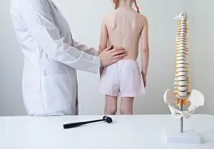 Arthritis Prints: A pediatric neurologist doctor examines the back of a 5-year-old girl who has back pain