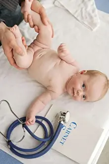Pediatrician examining the pelvis of 2-month-old baby girl to screen hip congenital dislocation
