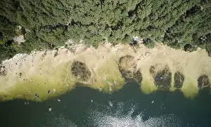 Sunbath Prints: People on lake beach above top drone view in bright sunny day