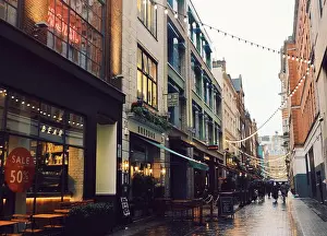 Shopping Prints: People shopping under the string lights on a rainy day on Kingly Street in Soho