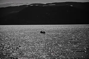 People tourist on the boat sailing through huge mountain under sunshine in uluabat lake in golyazi