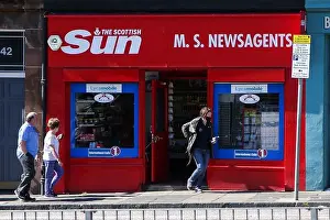 Newsagent Prints: People walks past a newsagent with The Scottish Sun shop fascia in Edinburgh, Scotland