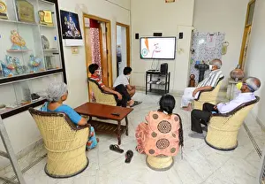 At Home Prints: People watches Indian Prime Minister Narendra Modi's address to the nation about COVID-19 on a television in their