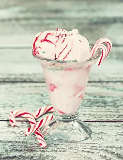 Peppermint ice cream with candy canes in a glass bowl