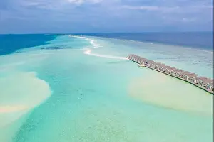 Perfect aerial landscape, luxury tropical resort or hotel with water villas and beautiful beach scenery. Amazing bird eyes view in Maldives, landscape