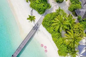 Perfect aerial landscape, luxury tropical resort or hotel with water villas and beautiful beach scenery. Amazing bird eyes view in Maldives, landscape