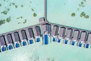 Perfect aerial landscape, luxury tropical resort or hotel with water villas and beautiful beach scenery. Amazing bird eyes view in Maldives, landscape