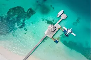 Perfect aerial landscape, luxury tropical resort or hotel with water villas and beautiful beach scenery. Amazing bird eyes view in Maldives, landscape