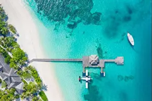 Perfect aerial landscape, luxury tropical resort or hotel with water villas and beautiful beach scenery. Amazing bird eyes view in Maldives, landscape