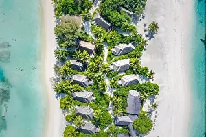 Perfect aerial landscape, luxury tropical resort or hotel with water villas and beautiful beach scenery. Amazing bird eyes view in Maldives, landscape