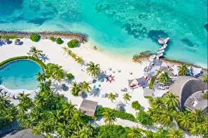 Perfect aerial landscape, luxury tropical resort or hotel with water villas and beautiful beach scenery. Amazing bird eyes view in Maldives, landscape