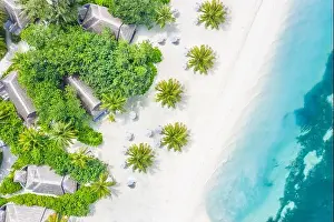 Perfect aerial landscape, luxury tropical resort or hotel with water villas and beautiful beach scenery. Amazing bird eyes view in Maldives, landscape
