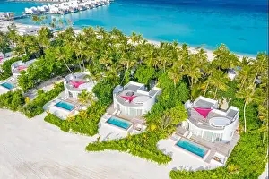 Perfect aerial landscape, luxury tropical resort or hotel with water villas and beautiful beach scenery. Amazing bird eyes view in Maldives, landscape