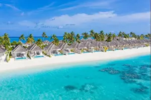 Perfect aerial landscape, luxury tropical resort or hotel with water villas and beautiful beach scenery. Amazing bird eyes view in Maldives, landscape