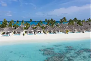 Perfect aerial landscape, luxury tropical resort or hotel with water villas and beautiful beach scenery. Amazing bird eyes view in Maldives, landscape