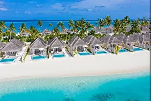 Perfect aerial landscape, luxury tropical resort or hotel with water villas and beautiful beach scenery. Amazing bird eyes view in Maldives, landscape