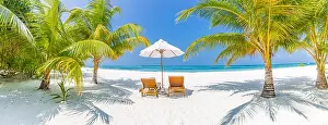 Perfect beach panorama, palms two sun beds and umbrella near the sea, idyllic beach scene. Tropical vacation and beach resort holiday banner concept