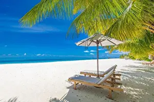 Perfect sunny beach. Idyllic tropical beach landscape for background. Couple honeymoon, romantic destination, freedom lounge chairs umbrella palm sand