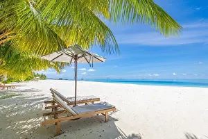 Perfect sunny beach. Idyllic tropical beach landscape for background. Couple honeymoon, romantic destination, freedom lounge chairs umbrella palm sand