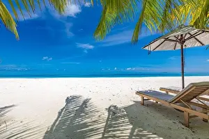 Perfect sunny beach. Idyllic tropical beach landscape for background. Couple honeymoon, romantic destination, freedom lounge chairs umbrella palm sand