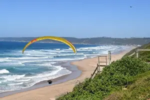 Person flying his paraglider on the beach of Wilderness in South Africa