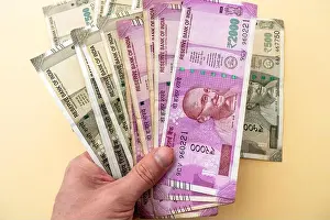 Exchanging Prints: Person holding heap of Indian 2000, 500, currency note rupees