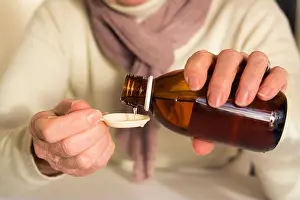 Adult Only Prints: Person pouring syrup into a spoon at home during winter