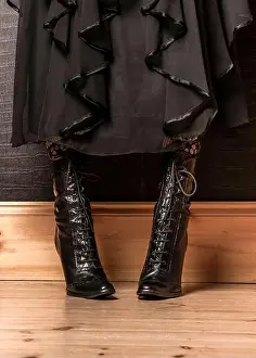 High Heels Prints: A person is wearing black lace-up boots and a black dress