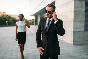Guarding Prints: Personal bodyguard in sunglasses and black business woman