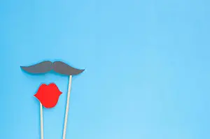 Flatlay Prints: Photo booth props glasses and moustache on blue background with copyspace