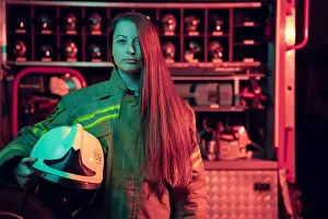 Firefighter Prints: Photo of female firefighter with long hair with helmet in her hands at fire station